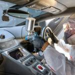 Autopflege, ein Profi führt eine Ozonbehandlung im Innenraum eines Autos durch