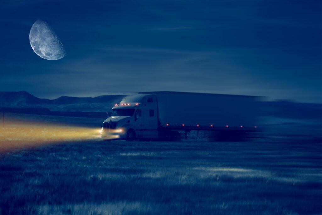 Nächtliche LKW Fahrt im Wüstengebiet, mit eingeschalteter LKW Beleuchtung